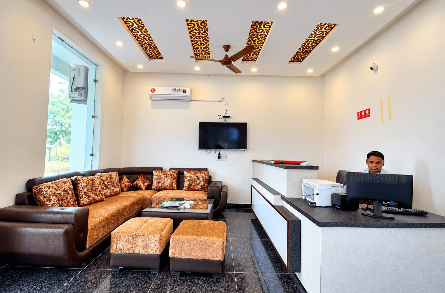 Hotel reception lounge with warm ceiling accents and guest seating